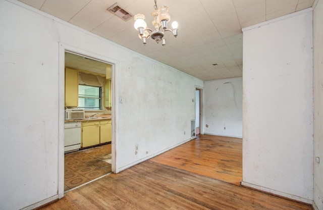 unfurnished room with a chandelier and wood finished floors