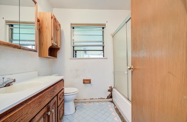 full bath featuring toilet, vanity, tile patterned flooring, and combined bath / shower with glass door