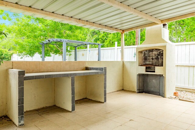 view of patio / terrace featuring a fireplace and fence