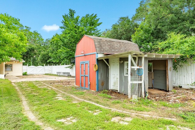 view of shed featuring fence and a gate