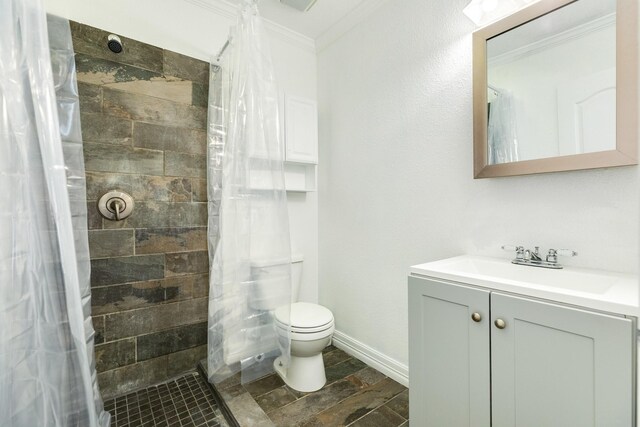 full bath featuring crown molding, toilet, tiled shower, and vanity