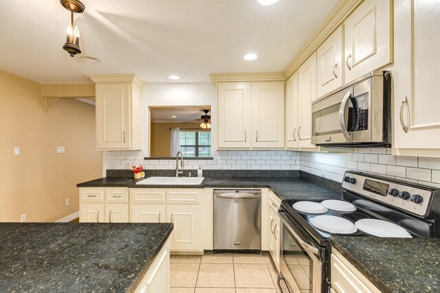 kitchen featuring stainless steel appliances, a sink, tasteful backsplash, light tile patterned floors, and ceiling fan