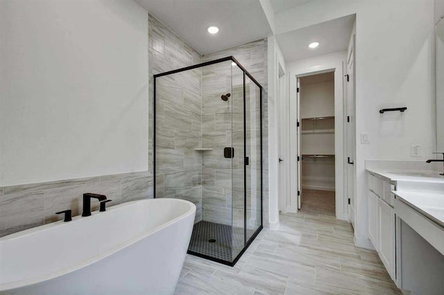 5818 Reef Ridge Dr, Manvel, TX 77578 - bathroom featuring a shower stall, a spacious closet, a freestanding tub, vanity, and recessed lighting