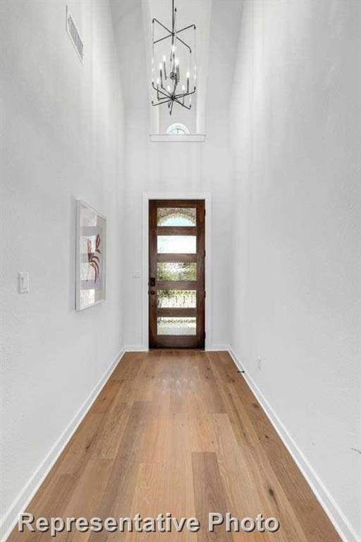 5818 Reef Ridge Dr, Manvel, TX 77578 - entryway featuring wood finished floors, a chandelier, baseboards, and a towering ceiling
