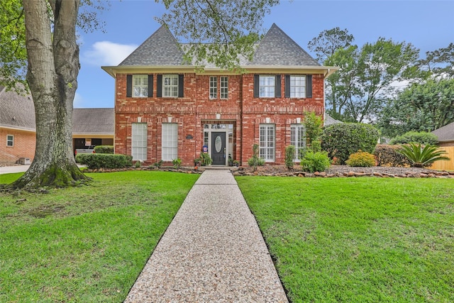 5810 Redwood River Dr, Kingwood, TX 77345 - georgian-style home with brick siding, a front yard, and a shingled roof