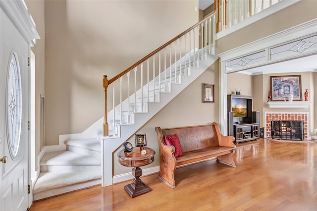 5810 Redwood River Dr, Kingwood, TX 77345 - foyer entrance featuring a high ceiling, stairway, wood finished floors, a fireplace with flush hearth, and baseboards