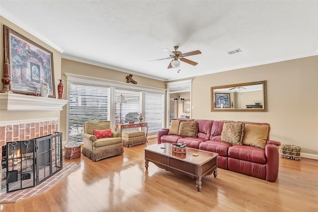 5810 Redwood River Dr, Kingwood, TX 77345 - living room with a ceiling fan, wood finished floors, ornamental molding, a tile fireplace, and a textured ceiling