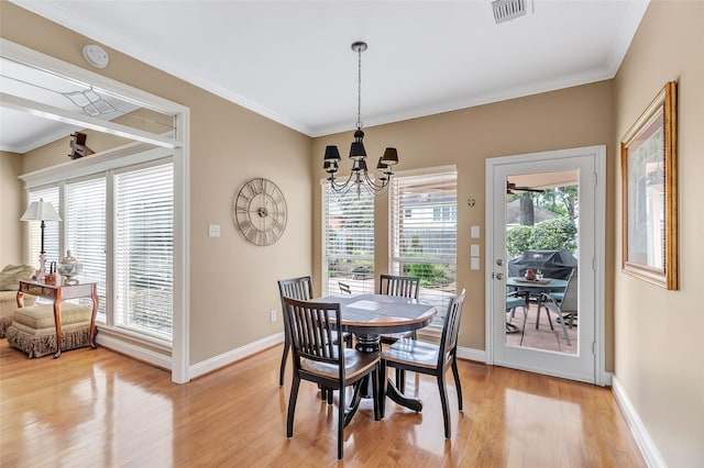 5810 Redwood River Dr, Kingwood, TX 77345 - dining room with a chandelier, light wood finished floors, baseboards, and crown molding