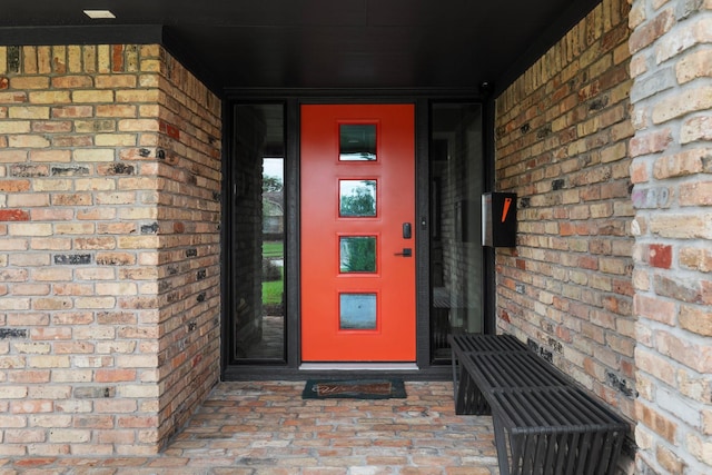 view of exterior entry with brick siding