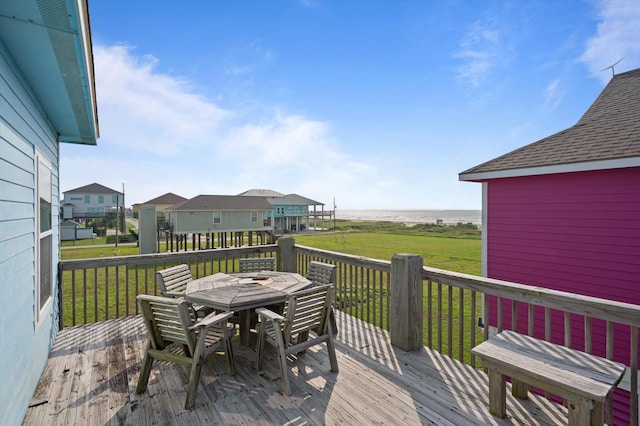 wooden deck featuring outdoor dining space and a lawn