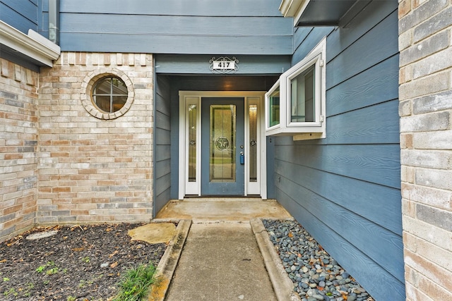 property entrance featuring brick siding