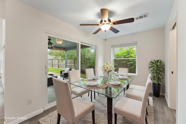dining room with a ceiling fan, baseboards, and wood finished floors