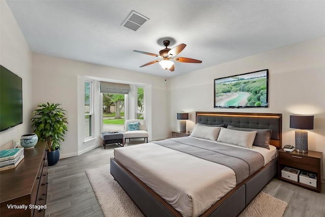 bedroom featuring wood finished floors, baseboards, and a ceiling fan