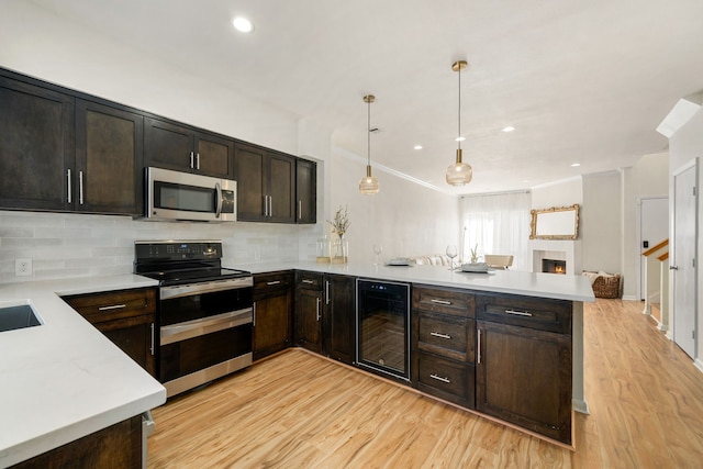 2100 Huldy St Unit 4, Houston, TX 77019 - kitchen featuring stainless steel appliances, wine cooler, a peninsula, light wood-style flooring, and light countertops
