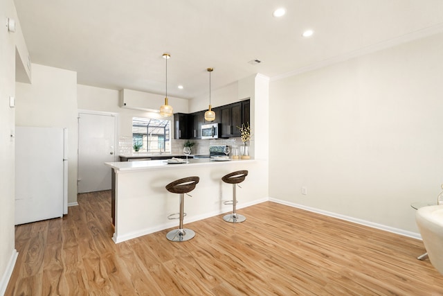 2100 Huldy St Unit 4, Houston, TX 77019 - kitchen featuring stainless steel microwave, range with electric stovetop, backsplash, light countertops, and light wood finished floors