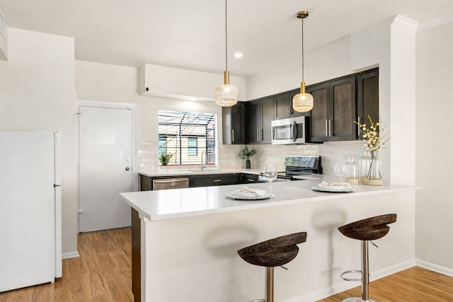 2100 Huldy St Unit 4, Houston, TX 77019 - kitchen with stainless steel appliances, a sink, light countertops, light wood-style flooring, and recessed lighting