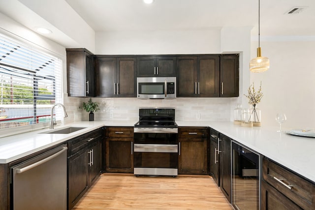 2100 Huldy St Unit 4, Houston, TX 77019 - kitchen featuring stainless steel appliances, beverage cooler, a sink, light wood-style flooring, and dark brown cabinets