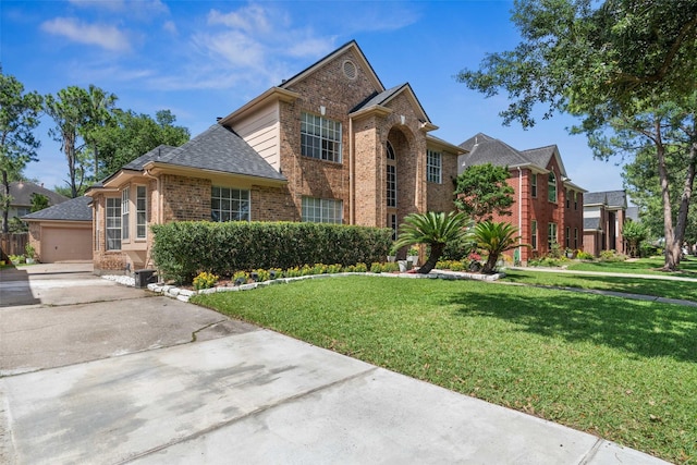 2112 Shadow Bay Cir, League City, TX 77573 - traditional-style home with brick siding, a front yard, a shingled roof, a garage, and driveway