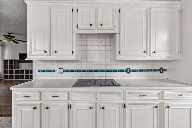 2112 Shadow Bay Cir, League City, TX 77573 - kitchen featuring black electric stovetop, ceiling fan, light countertops, white cabinetry, and backsplash