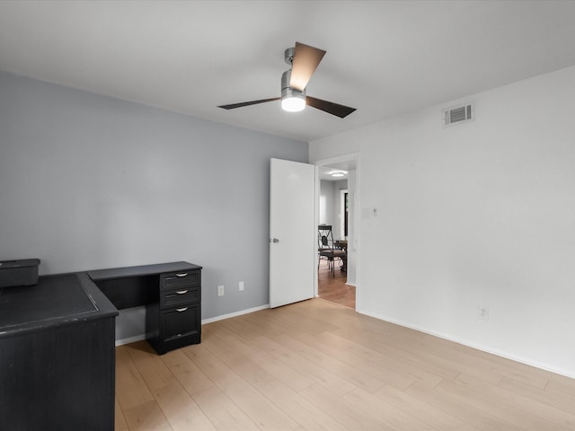 unfurnished office featuring ceiling fan, light wood finished floors, and baseboards