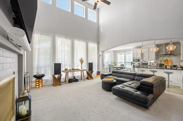 2723 Camellia Ave, Brookshire, TX 77423 - living area featuring ceiling fan, arched walkways, a high ceiling, and a fireplace