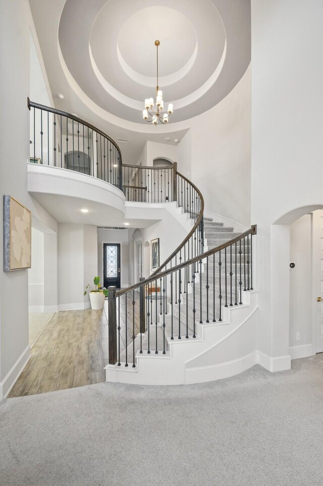 2723 Camellia Ave, Brookshire, TX 77423 - stairs with a high ceiling, arched walkways, a chandelier, a raised ceiling, and wood finished floors