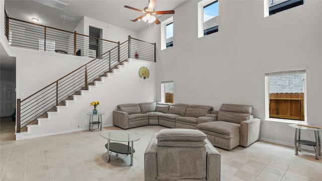 22218 Delphin Grove Dr, Hockley, TX 77447 - living area with a towering ceiling, stairway, baseboards, tile patterned flooring, and ceiling fan