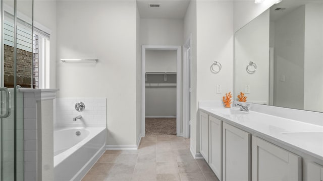 22218 Delphin Grove Dr, Hockley, TX 77447 - full bathroom featuring a bath, baseboards, double vanity, tile patterned floors, and a spacious closet