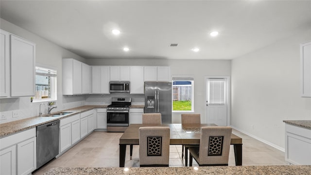 22218 Delphin Grove Dr, Hockley, TX 77447 - kitchen with stainless steel appliances, a sink, backsplash, white cabinets, and recessed lighting