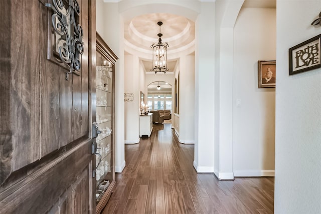 2103 Matagorda Ln, Friendswood, TX 77546 - hall with arched walkways, dark wood-type flooring, baseboards, and a tray ceiling