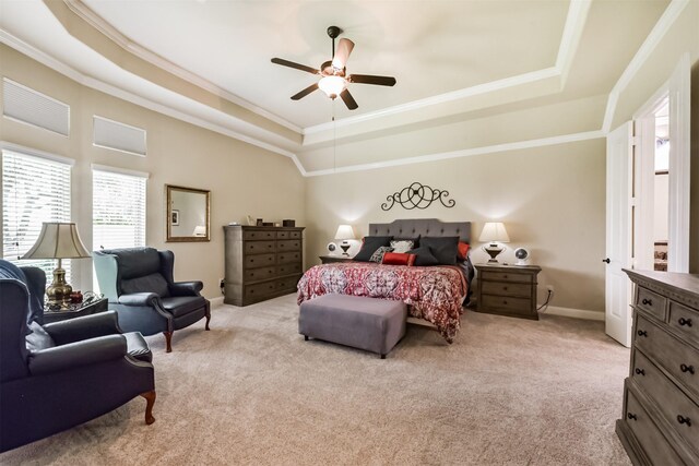 bedroom featuring a raised ceiling, crown molding, light carpet, baseboards, and a ceiling fan