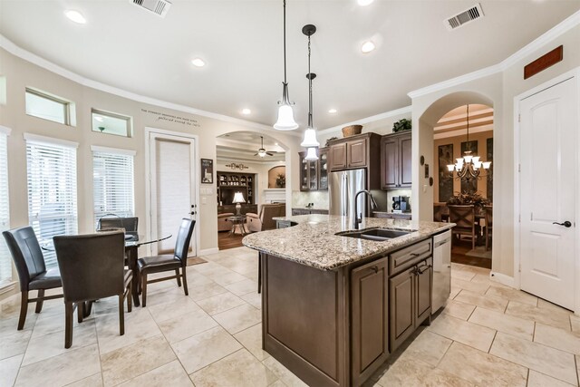 kitchen featuring a sink, arched walkways, ornamental molding, dark brown cabinetry, and appliances with stainless steel finishes