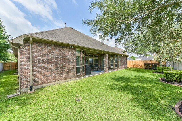 rear view of property with brick siding, roof with shingles, and a patio