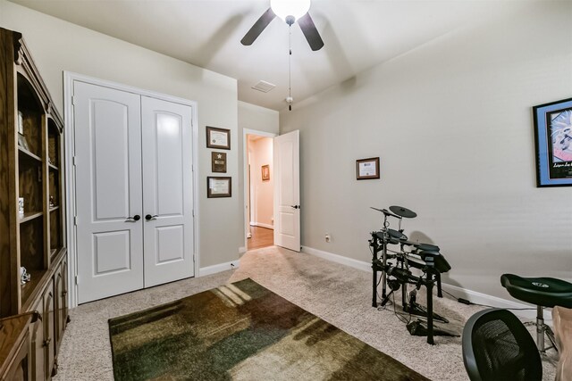 office space featuring carpet flooring, a ceiling fan, and baseboards