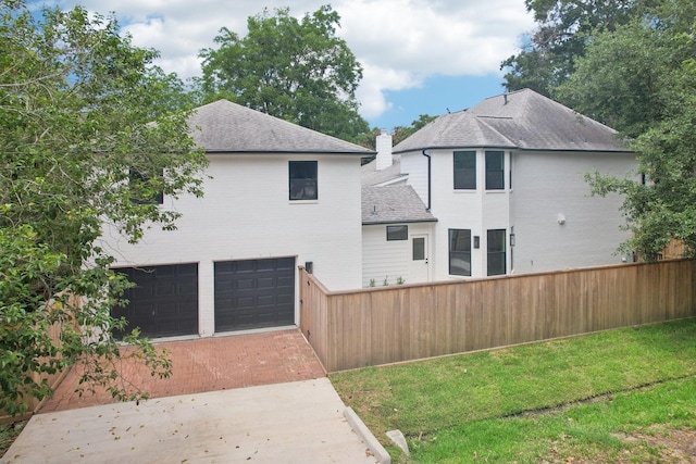 6291/2 Rancho Bauer Dr, Houston, TX 77079 - back of property featuring an attached garage, decorative driveway, a chimney, and roof with shingles