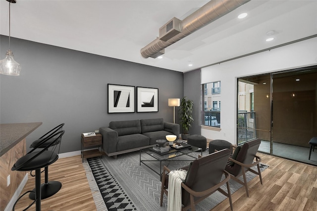 living room featuring light wood-style floors, baseboards, and recessed lighting