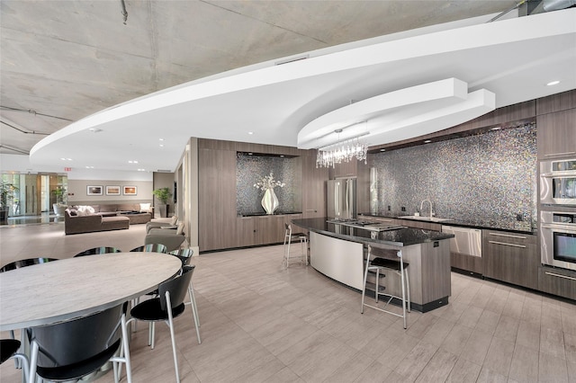 kitchen with stainless steel appliances, modern cabinets, a breakfast bar, a kitchen island, and recessed lighting