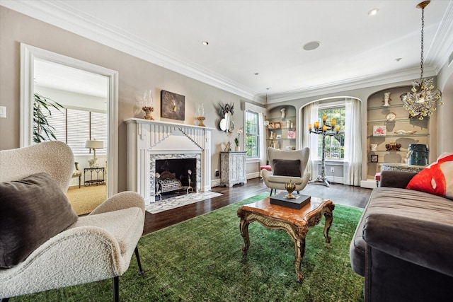 living area with wood finished floors, crown molding, healthy amount of natural light, and a high end fireplace