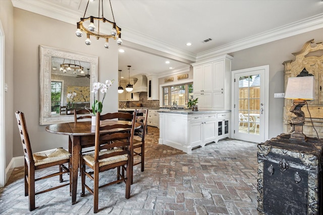 dining area with a chandelier, crown molding, brick flooring, and recessed lighting