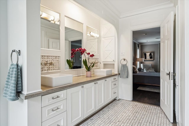 full bathroom with crown molding, double vanity, backsplash, and connected bathroom