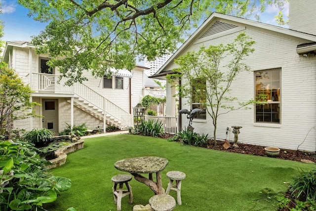 view of green lawn with stairs
