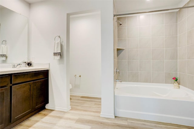 12319 Tranquil Pines Dr, Houston, TX 77014 - full bathroom featuring vanity, wood finished floors, toilet, bathtub / shower combination, and baseboards