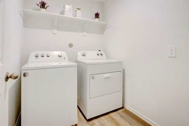 12319 Tranquil Pines Dr, Houston, TX 77014 - washroom featuring washing machine and dryer, light wood-style flooring, and baseboards