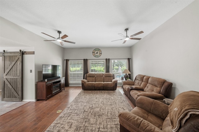 996 Scroggins Ln, Waller, TX 77484 - living room with a ceiling fan, a barn door, vaulted ceiling, and wood finished floors