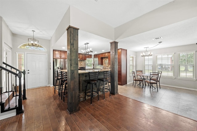 996 Scroggins Ln, Waller, TX 77484 - bar area featuring a chandelier, ornate columns, stainless steel fridge with ice dispenser, and baseboards