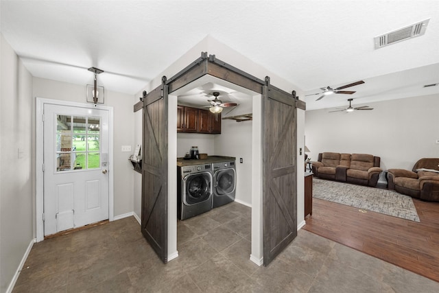 996 Scroggins Ln, Waller, TX 77484 - laundry room with a barn door, washer and dryer, cabinet space, and a ceiling fan