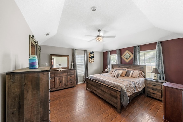 996 Scroggins Ln, Waller, TX 77484 - bedroom featuring lofted ceiling, dark wood-style floors, ceiling fan, and a barn door