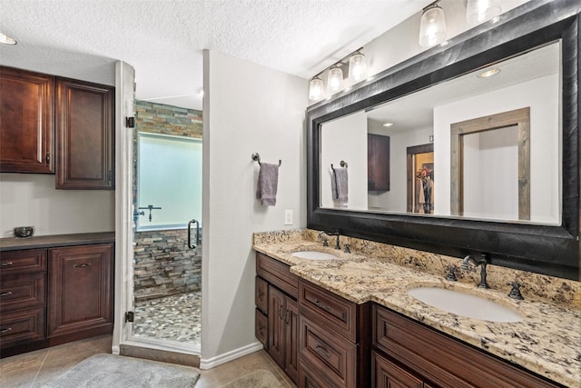 996 Scroggins Ln, Waller, TX 77484 - full bathroom with a shower stall, double vanity, tile patterned flooring, and a textured ceiling
