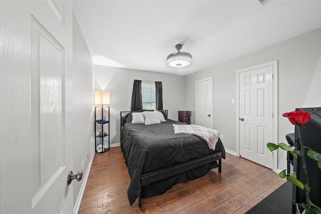 996 Scroggins Ln, Waller, TX 77484 - bedroom featuring wood-type flooring, baseboards, and a textured ceiling