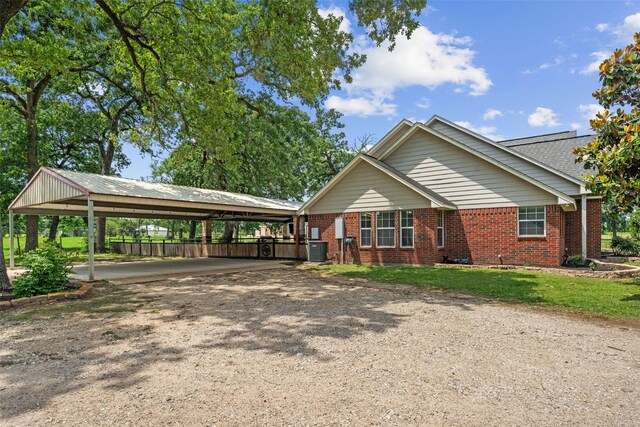 996 Scroggins Ln, Waller, TX 77484 - view of front facade with brick siding, dirt driveway, fence, and central AC unit